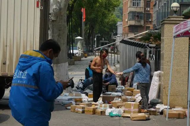 武汉一所高校封闭管理,校内的快递都堆放在门口。中青报·中青网见习记者李强/摄