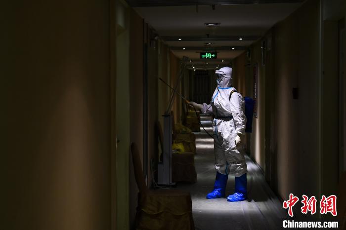 冯丕文穿着厚厚的防护服在酒店消毒。 武俊杰 摄
