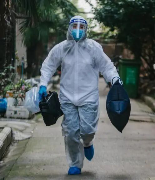 邱琳玉手持氧枕、救护箱奔跑。这张照片,被刊登上北京的公交站台。 受访者供图