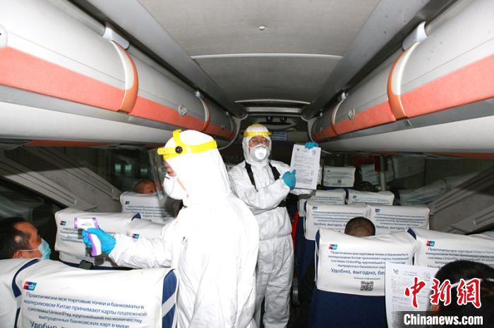 哈尔滨海关所属绥芬河海关关员对入境客车实施登临检疫。 郑家昕 摄