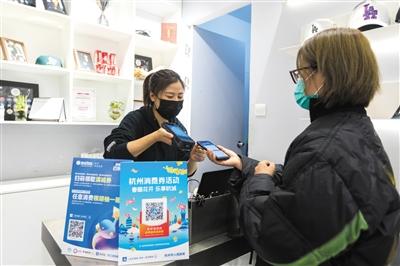 一名顾客在杭州银泰使用支付宝里的消费券付款。