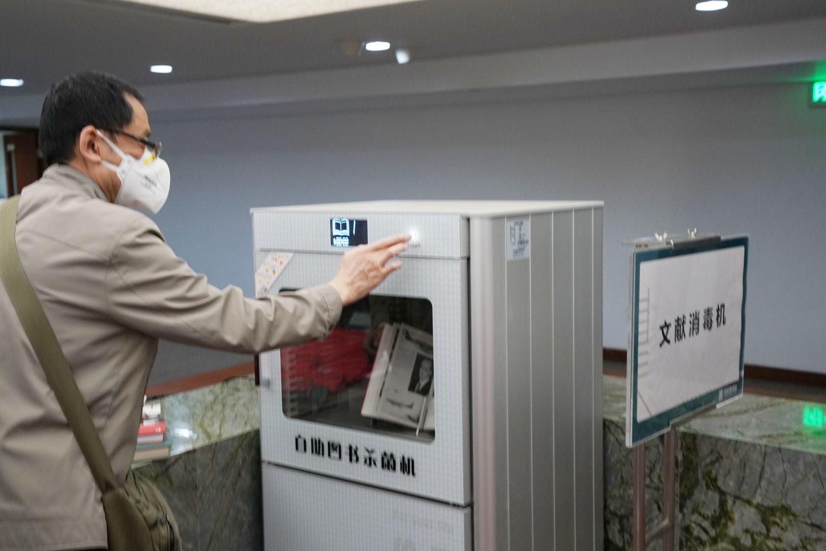 读者利用自助图书消毒设备为书籍消毒。新京报记者 浦峰 摄