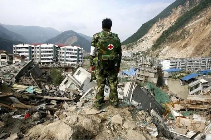 ▲2008年5月15日，北川县城，一位医护人员站在倒塌的废墟顶部望着整个县城，背对着镜头的他已是眼泪纵横。