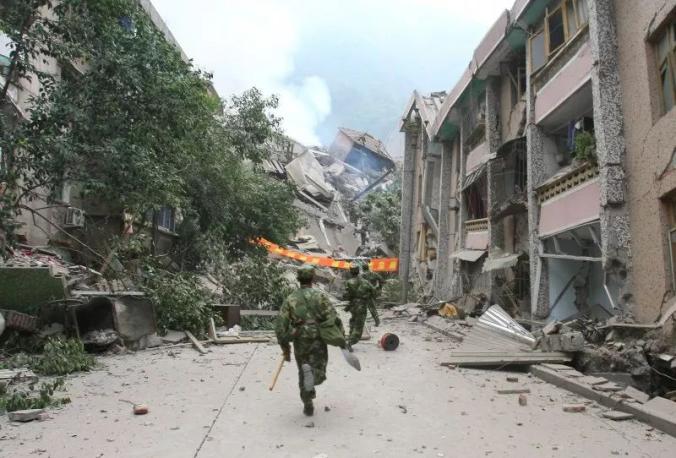 ▲2008年5月13日,四川绵阳北川县,武警兵士奔向衡宇坍塌现场,救济被困伤员。