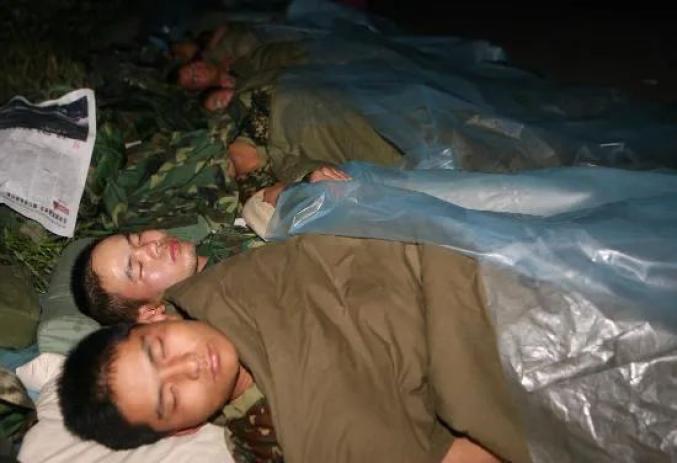 ▲2008年5月15日破晓,加入抗震救灾的济南军区某部兵士在汶川县映秀镇陌头苏息。
