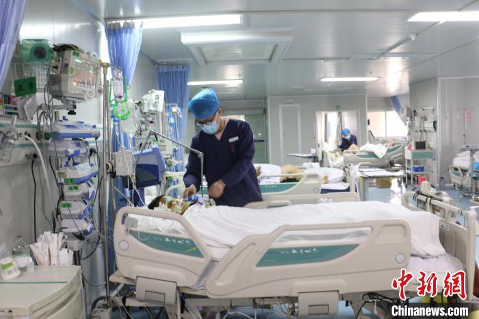 图为柳州市人民医院ICU男护士唐天泽在护理病患。 林馨 摄
