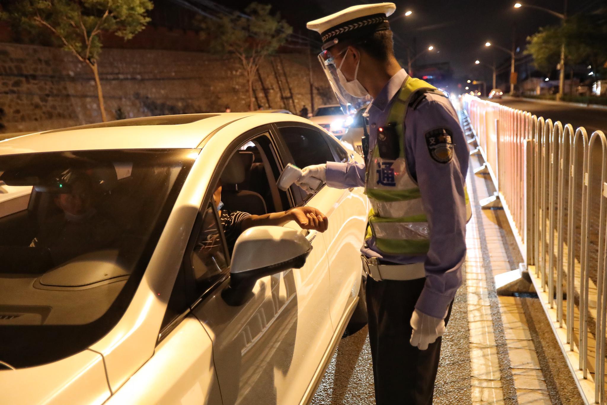 民警先行使测温枪对驾驶员举行测温,对付体温无非常的驾驶员才行使快速测酒仪检测是否酒驾。摄 新京报记者 王贵彬