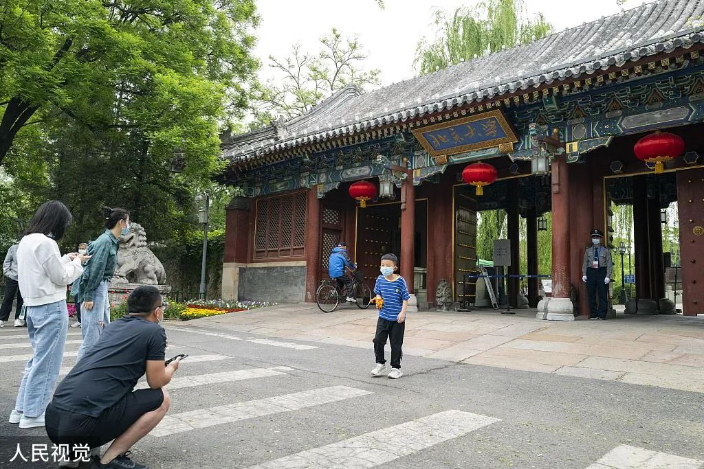 北京大学122周年校庆当天,游客在校门前参观 图丨视觉中国 *应采访