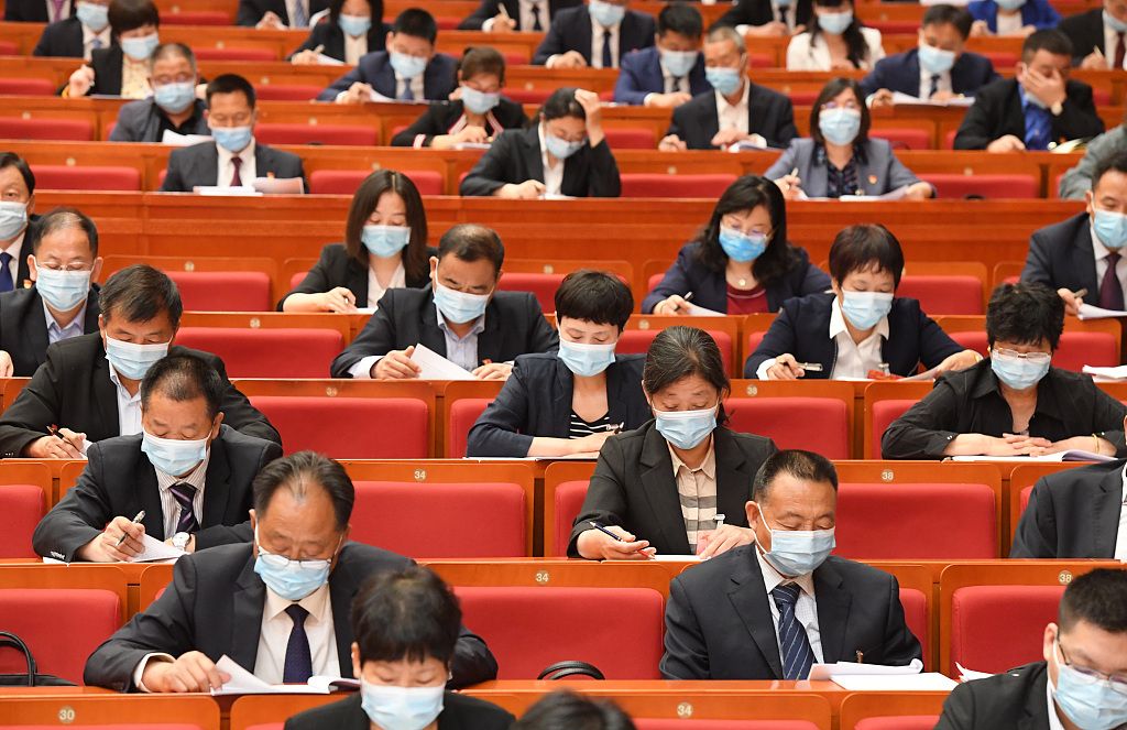 2020年5月14日,郑州市第十五届人大三次集会时代,人大代表均佩带口罩,距离就座。图/视觉中国