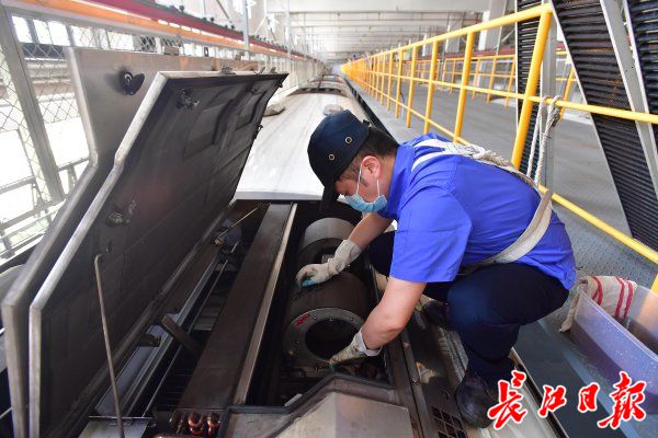 5月18日,地铁野芷湖车辆段7号线检修车间,工作人员在列车车顶擦洗空调机舱。记者李永刚 摄