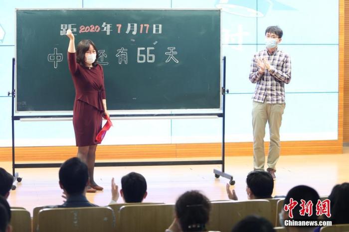 资料图:5月11日,在位于北京市西城区的北京师范大学附属实验中学内,教师代表为中考倒计时牌揭幕。当日,北京初三年级学生返校复课。 中新社记者 蒋启明 摄