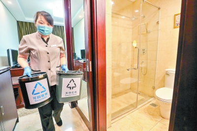 昨天,北京会议中心客房内,工作人员在清运“可回收物”和“其他垃圾”两个垃圾桶。 本报记者 武亦彬摄