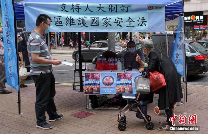 一位長者簽名後豎起大拇指支持立法。中新社記者 張煒 攝