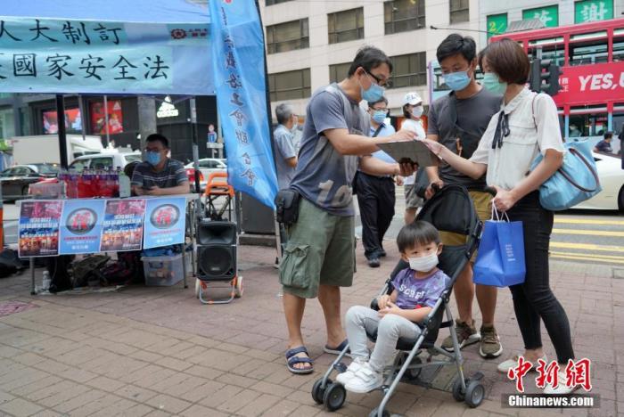一對年輕夫婦簽名支持國安立法。中新社記者 張煒 攝