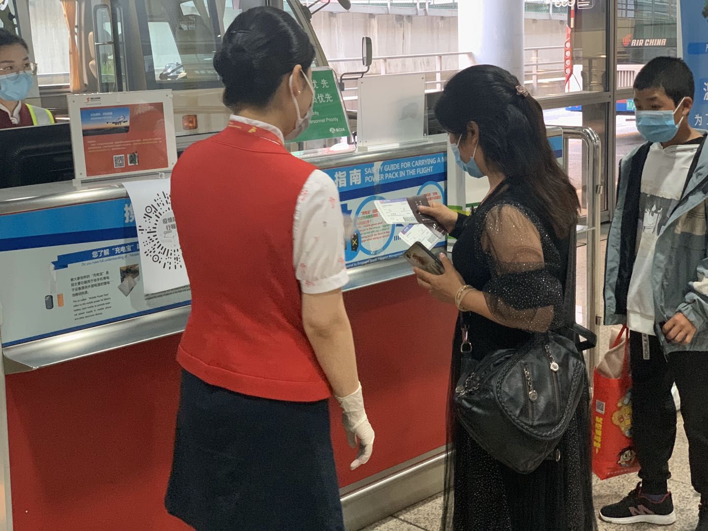深航地面事情职员帮忙游客完成相干挂号。深圳航空供图