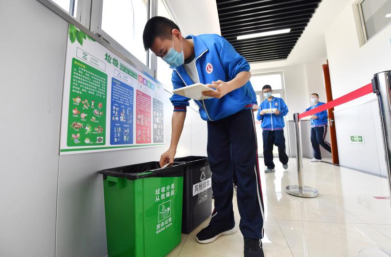 教学楼楼道贴有垃圾分类指南，学生就餐后按厨余垃圾和其他垃圾分类投放。 新京报记者 李木易 摄
