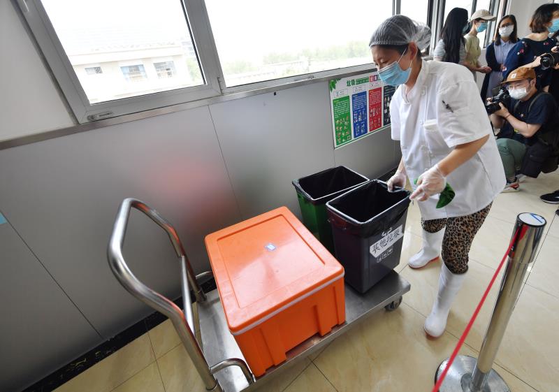 学生就餐完毕，食堂工作人员将垃圾回收。 新京报记者 李木易 摄