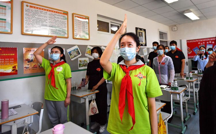 “返校复课第一课上”,“学生”面对国旗敬礼。