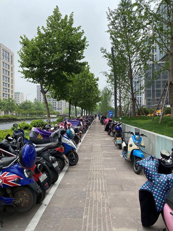 杭州市区,电动自行车停满了停车位,不得不占用一部分人行道。郭敏 图