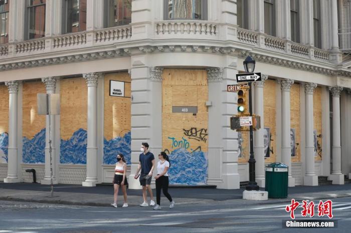 当地时间5月3日,纽约SOHO商业区许多商店仍然用木板封闭着店铺,随着纽约疫情的好转,该商区街头逐渐有稀疏的行人。 中新社记者 廖攀 摄