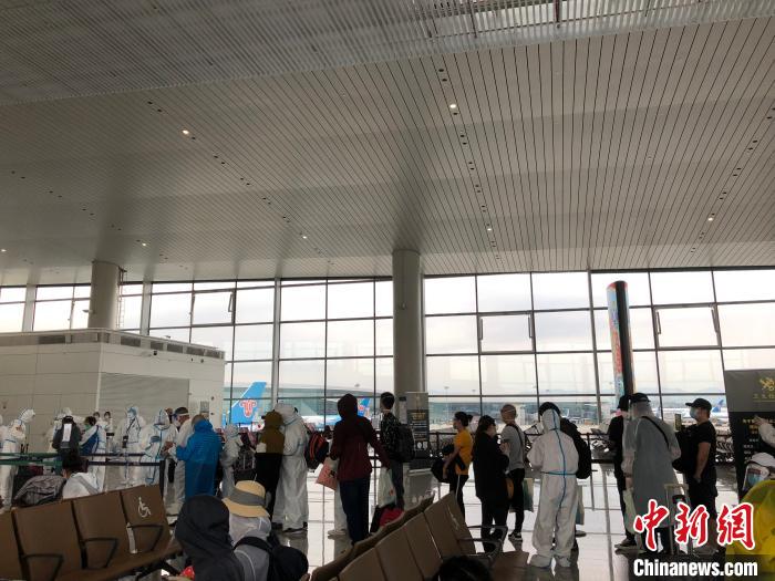 安抵广州的同胞,在列队期待担当体检。何乐(通信员) 摄