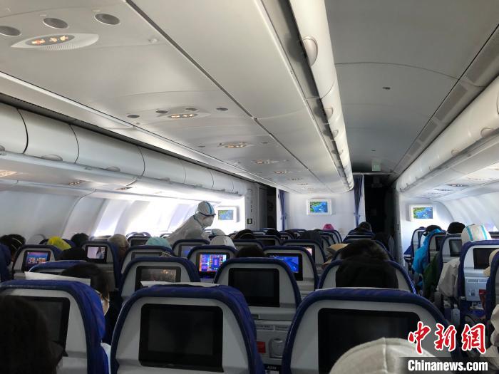 航班上,身着防护服的南方航空空姐在办事。何乐(通信员) 摄