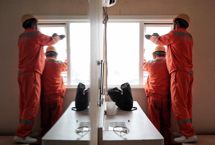 工人拆除违建客房的窗户。