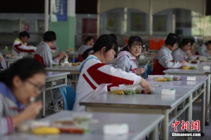 资料图:学校食堂内,门生保持肯定的间隔就餐。中新社记者 蒋启明 摄