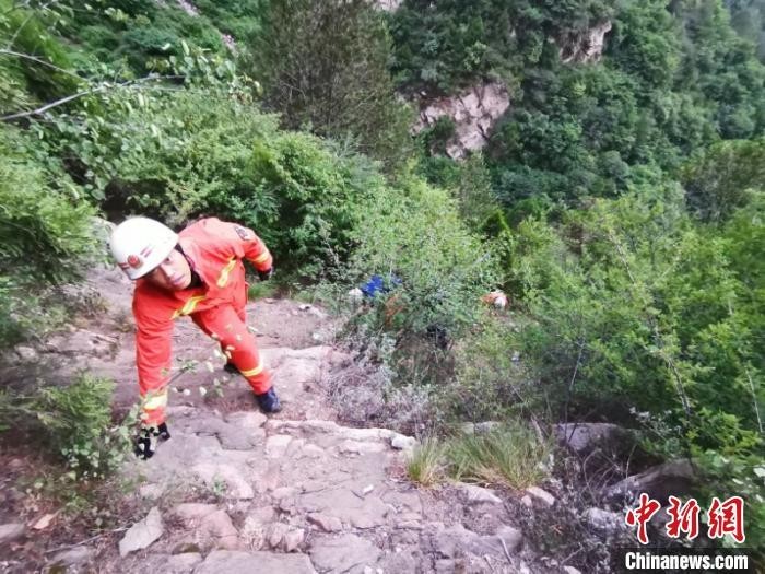 图为消防救援人员奋力登山。 周洋 摄