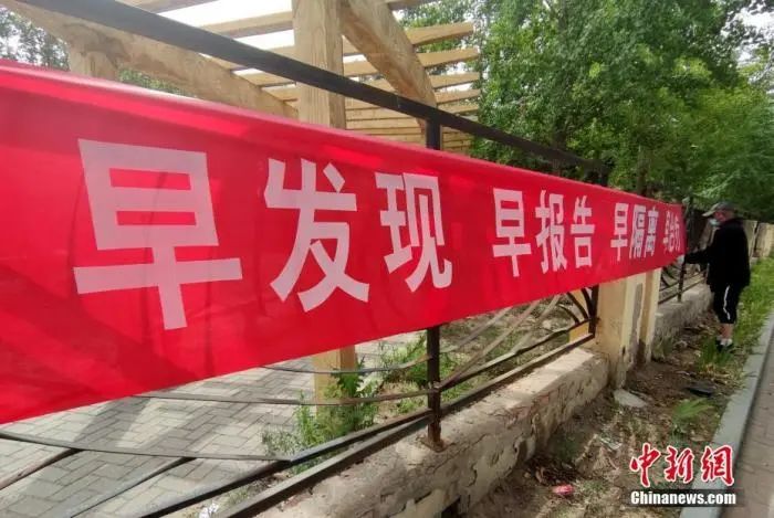 6月16日,北京花乡区域一街道边,事情职员正在悬挂防疫宣传横幅。中新社记者 张宇 摄