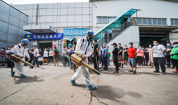 岳各庄批发市场,蓝天救援队正对市场进行消杀,商户和职工排队进行核酸检测。