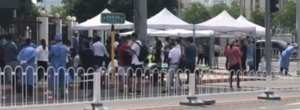 市民在医院门前排起长队。视频截图