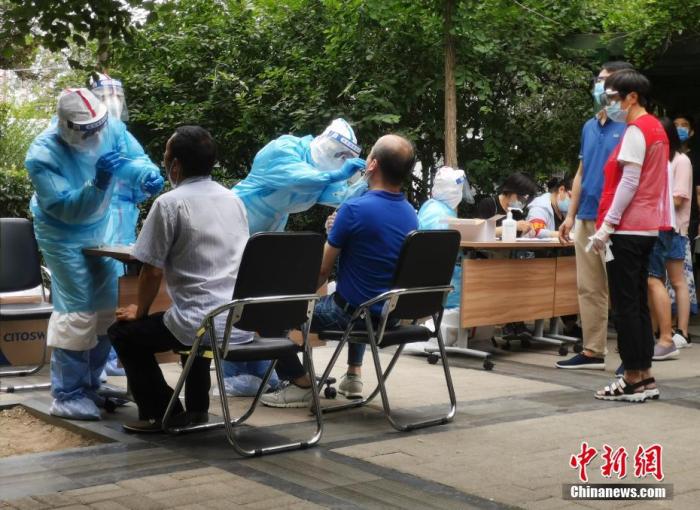 6月17日,北京西城一实施封闭管理的社区,工作人员为社区居民进行核酸检测。中新社记者 杜洋 摄