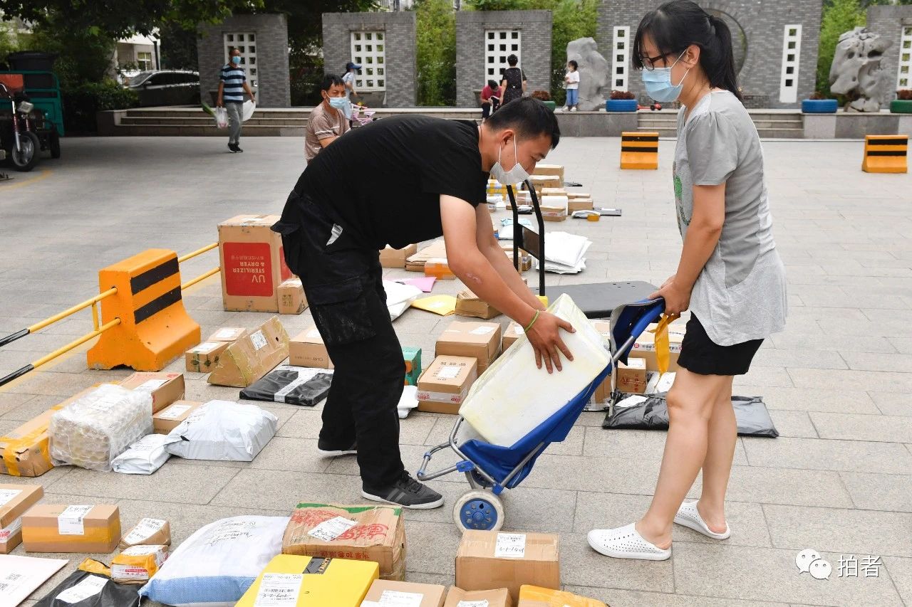 △6月17日,向阳区一小区已克制快递员上门送件,快递员需接洽住民到小区进口处领取包裹。拍照/新京报记者吴宁