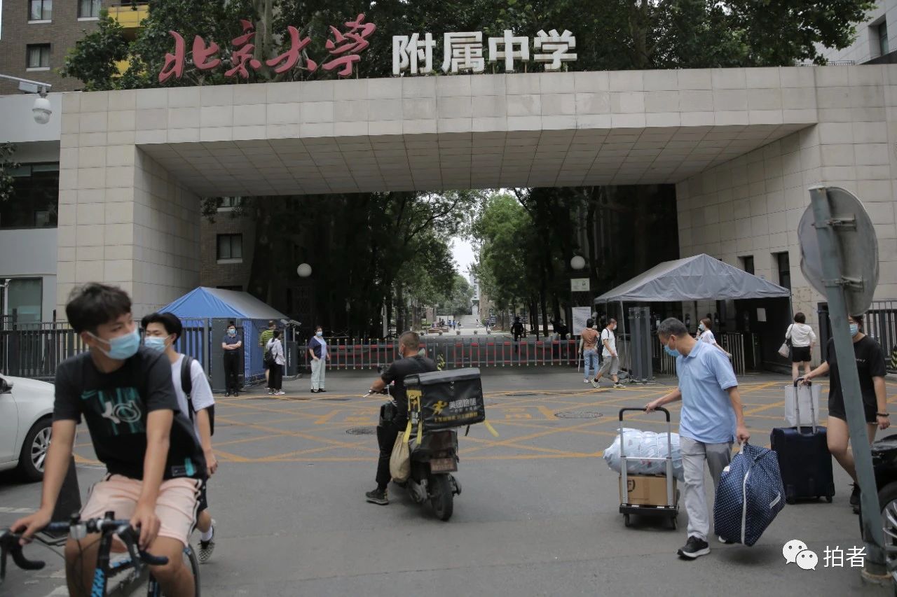 △6月17日,北大附中门口,家长拉着孩子的进修物品脱离。拍照/新京报记者郑新洽