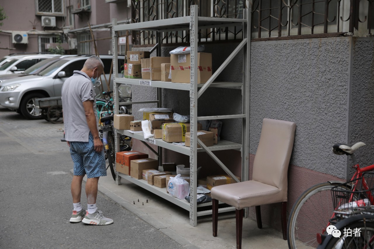 △6月17日,海淀区海淀南路北社区,快递被寄放在小区进口处的快递架上。拍照/新京报记者郑新洽