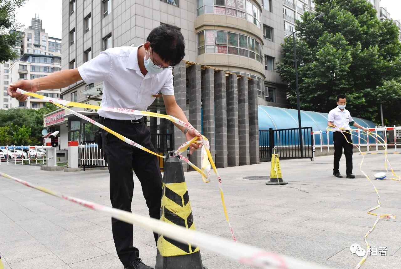 △6月17日,向阳区一小区,物业事情职员在小区进口处配置警戒线。拍照/新京报记者吴宁