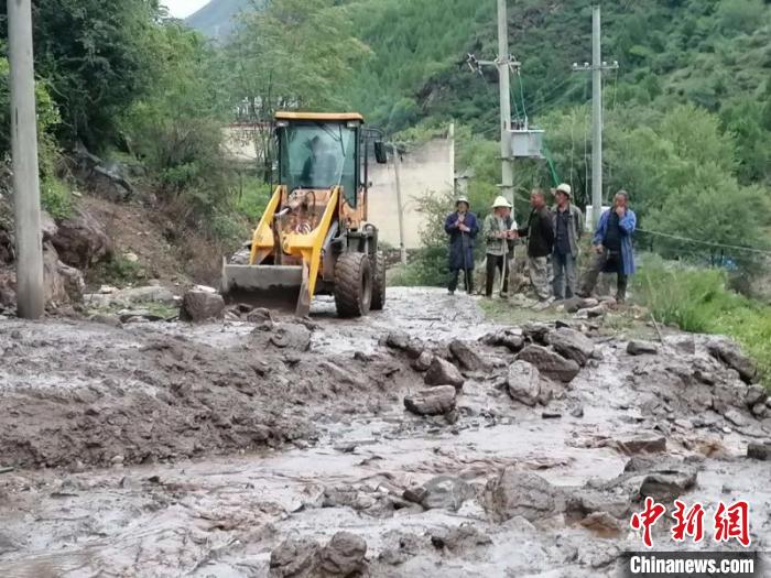 抢险职员正在清算门路上的泥浆和石头等。丹巴宣提供