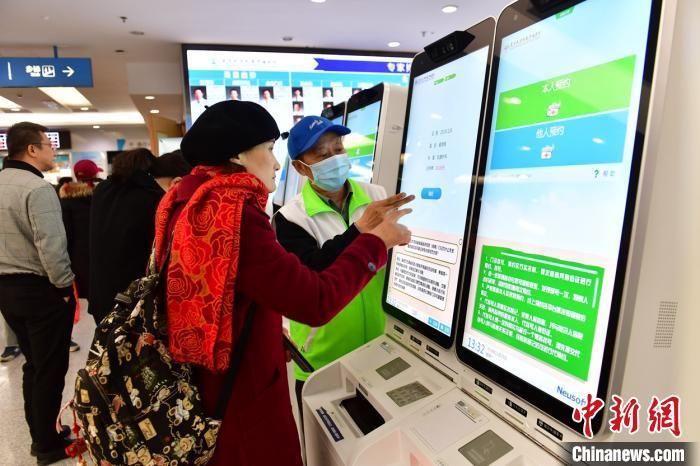 資料圖:患者在指導下使用人臉識別系統(tǒng)預約專家號。 王廣兆 攝
