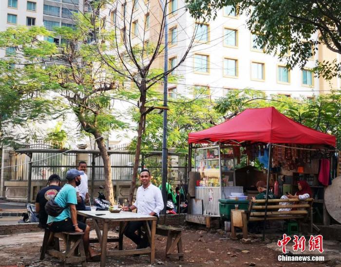 资料图:当地时间6月8日傍晚,印尼首都雅加达市中心一处空地上,民众在露天摊位上消费。 中新社记者 林永传 摄