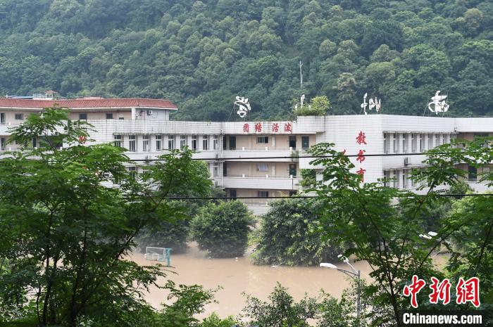 图为倒灌进城区的洪水将一所小学淹没。 周毅 摄