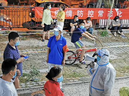 20日破晓,社区事情职员不停提示人们保持间隔。《中国谋划报》记者郝成摄