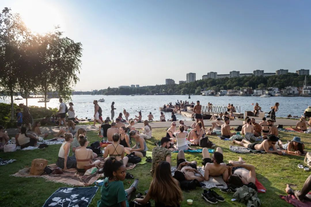 6月24日，斯德哥尔摩民众在湖边公园晒日光浴，当天气温达30摄氏度。