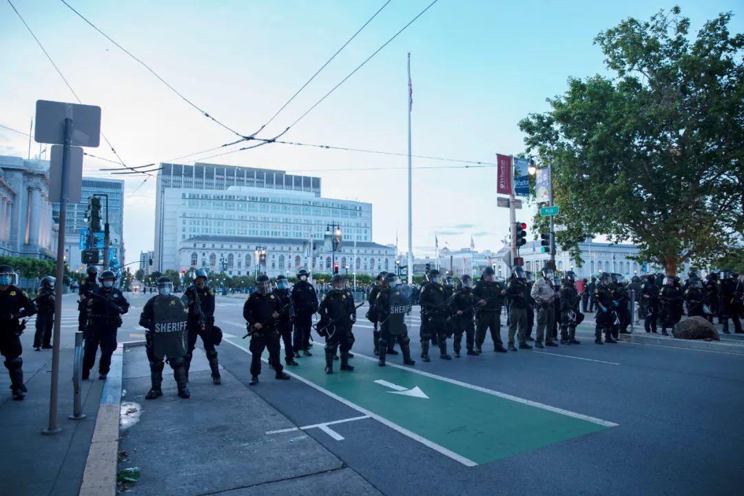 5月31日,在美国加利福尼亚州旧金山市,人们参加抗议活动,警察严阵以待。新华社发(李建国摄)
