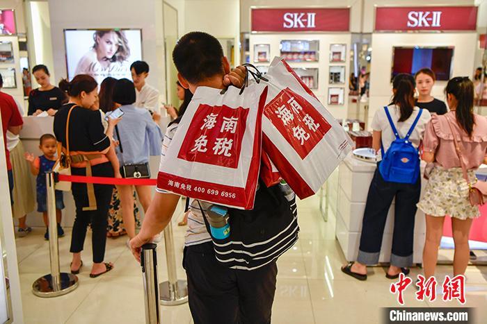 资料图为一位男主顾在海口日月广场免税店内列队买单。 中新社记者 骆云飞 摄