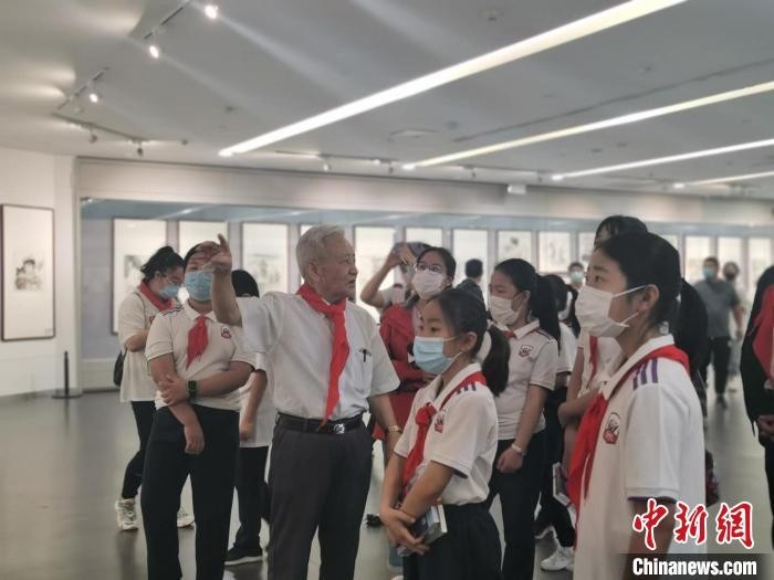 “这幅如民间木板年画一样,颜色为红黄蓝绿几种;那一幅是反映农村儿童生活……”画展上,佩戴红领巾的张连瑞,不厌其烦地为观展儿童介绍作品,讲解其背后故事。 高雨晴 摄