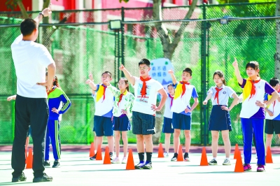 昨天,小学六年级开学第一天,丰台一小为返校复课的学生们安排了体育课,帮助居家已久的孩子们恢复身体。 本报记者 邓伟摄