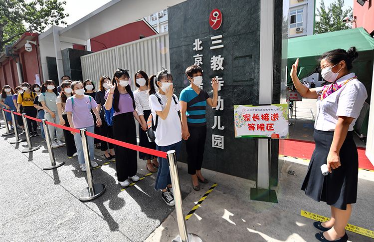 6月3日,北京市西城区三教寺幼儿园,教师欢迎返园“小朋友”和“小朋友家长”。