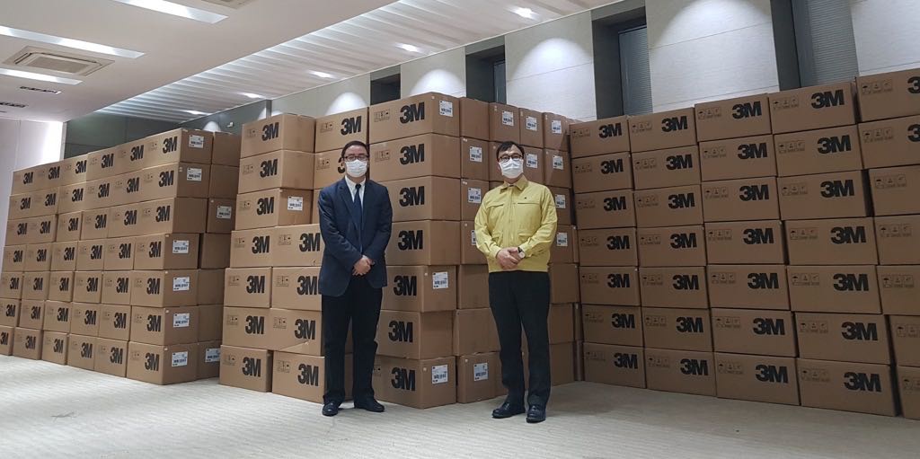 2月27日,韩国驻上海总领事崔泳杉(右)与上海市人民政府外事办公室人士在将运往韩国的口罩前合影。 韩国驻上海总领事馆 供图