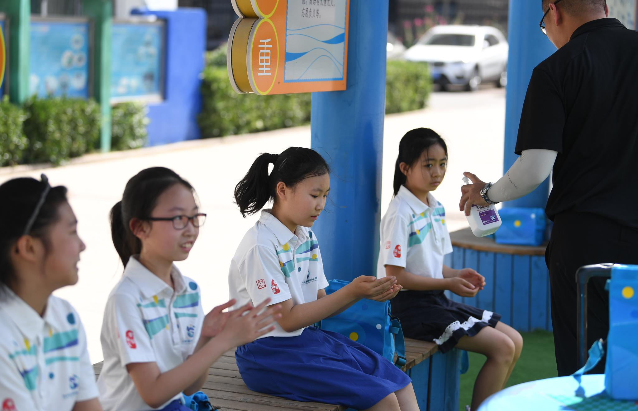 6月8日，丰台五小，四五年级返校复课，课间教师为同学进行手部消毒。